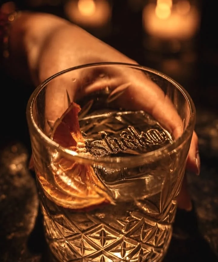 Verre gravé Shoko tenu à la lueur des bougies
